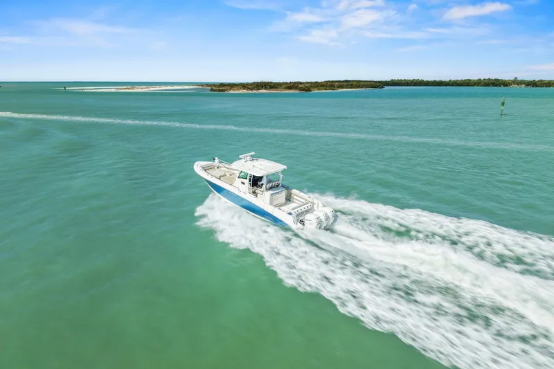 Slide: The Image of 2017 Boston Whaler 350 Outrage cruising on turquoise waters under a clear blue sky. - 6
