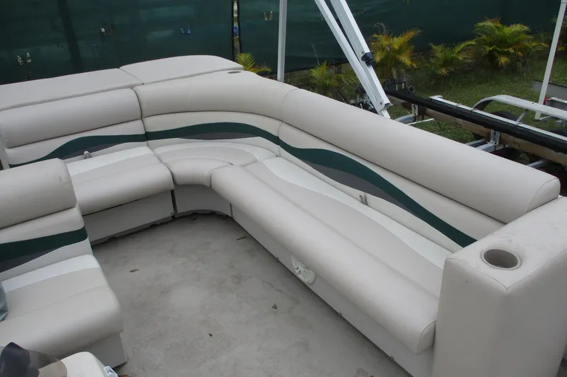 Slide: The Image of 2005 Bennington 21 boat interior with beige seating and green accents. - 11