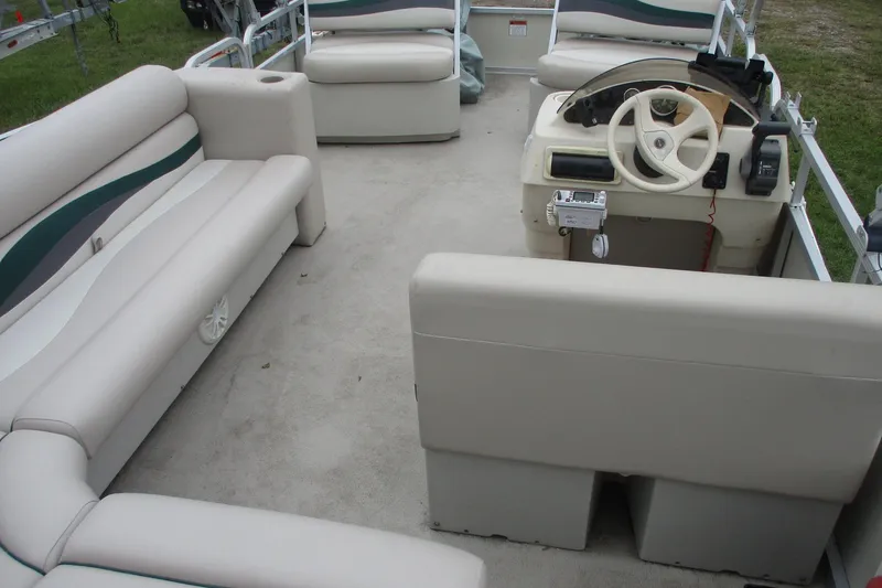 Slide: The Image of 2005 Bennington 21 pontoon boat interior with beige seating and steering console. - 12