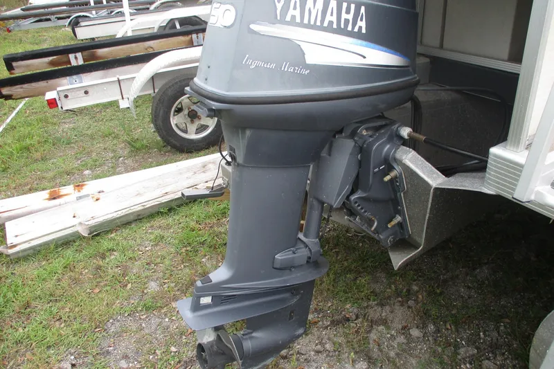 Slide: The Image of Yamaha outboard motor on a 2005 Bennington 21 boat, parked on grass. - 3