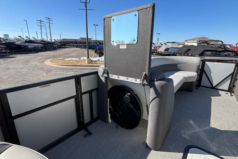 Slide: The Image of 2026 Viaggio X24U pontoon boat interior with seating and helm, parked outdoors. - 11