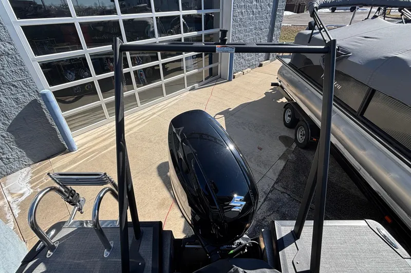 Slide: The Image of 2026 Viaggio X24U boat with outboard motor, parked near a garage. - 19