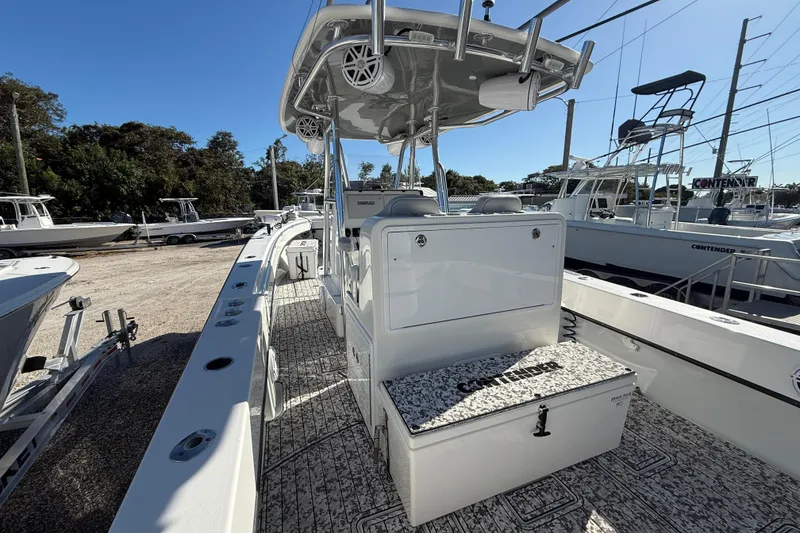 Slide: The Image of 2016 Contender 35 ST boat with center console and spacious deck in a marina setting. - 15