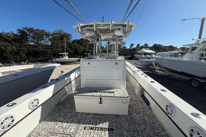 Slide: The Image of 2016 Contender 35 ST boat interior with helm, seating, and storage, docked under clear sky. - 19
