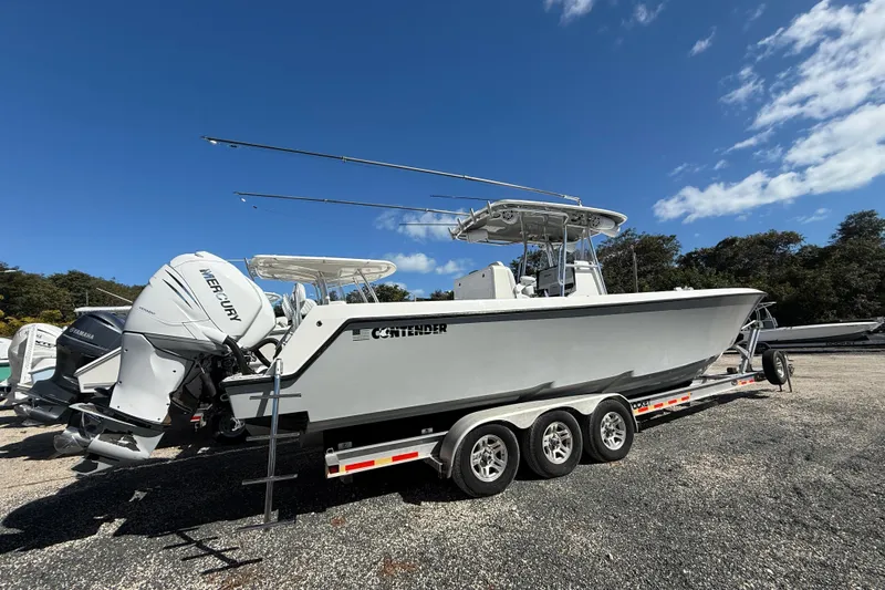 Slide: The Image of 2016 Contender 35 ST boat on trailer with Mercury engines under clear blue sky. - 22