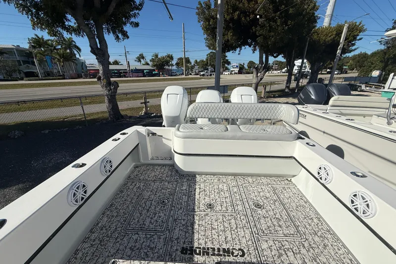 Slide: The Image of 2016 Contender 35 ST boat interior with seating and deck, parked outdoors. - 6