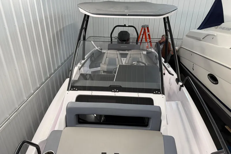 Slide: The Image of 2023 Axopar 25 Cross Bow boat in storage, featuring sleek design and modern seating. - 17