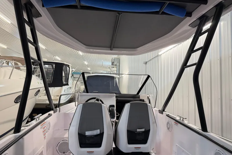 Slide: The Image of 2023 Axopar 25 Cross Bow interior with dual seats and modern design in a showroom. - 18