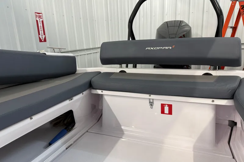 Slide: The Image of 2023 Axopar 25 Cross Bow interior with gray seating and fire extinguisher sign. - 6