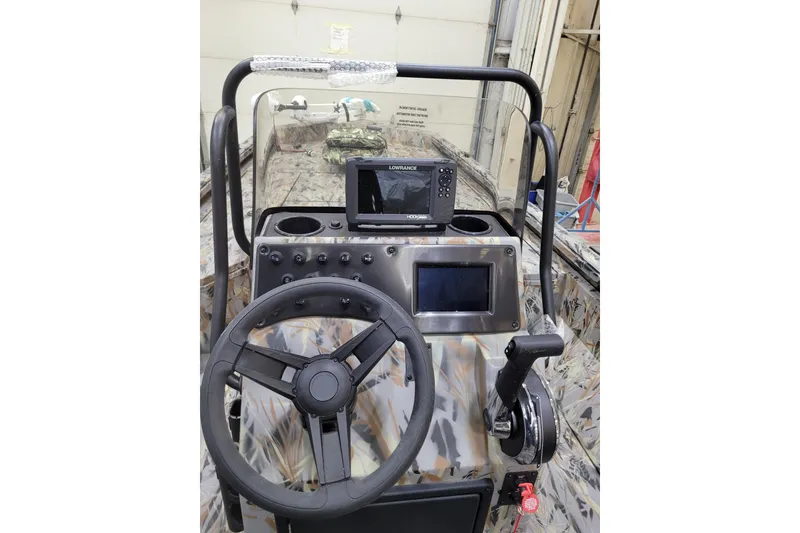 Slide: The Image of 2025 Ranger RB210 boat console with steering wheel, controls, and navigation display. - 10