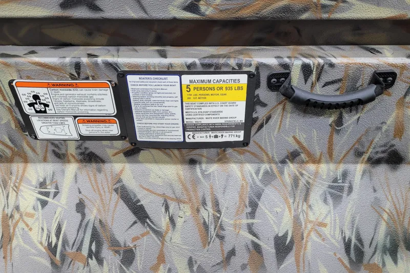 Slide: The Image of Ranger RB210 2025 boat warning labels and capacity information on camo-patterned surface. - 11