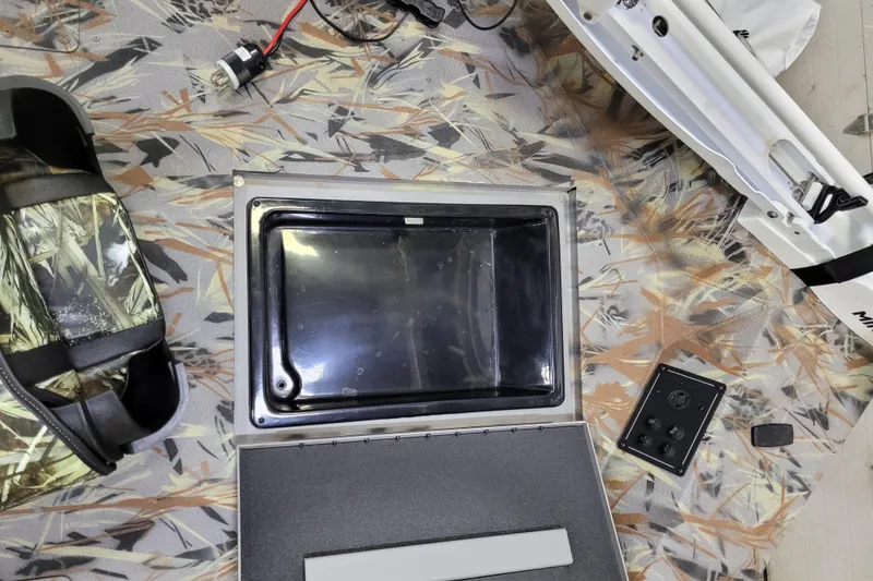 Slide: The Image of Open compartment on 2025 Ranger RB210 boat with camo pattern and electronic components. - 25