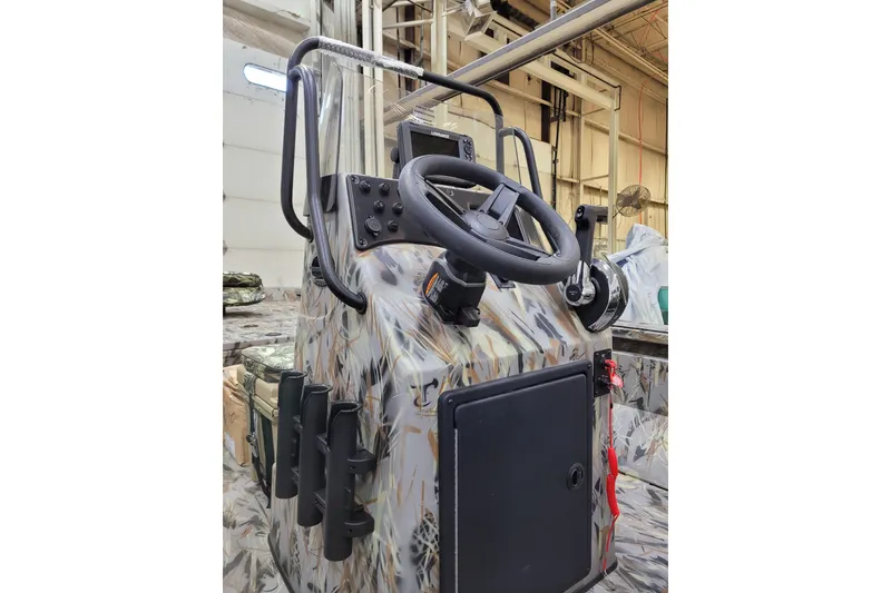 Slide: The Image of 2025 Ranger RB210 boat console with camouflage design and steering wheel in a warehouse setting. - 9