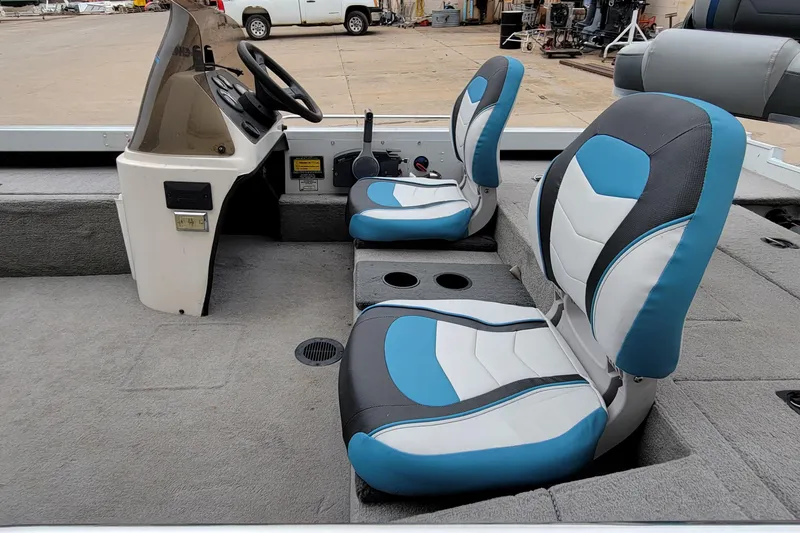 Slide: The Image of 1999 Ranger 107 Cherokee boat interior with blue and white seats, steering console visible. - 13