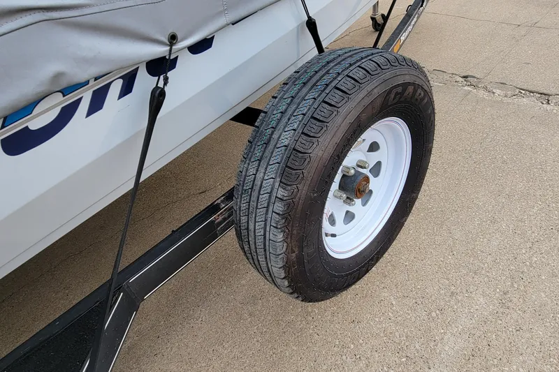 Slide: The Image of Trailer tire on a 1999 Ranger 107 Cherokee boat trailer, parked on concrete. - 24