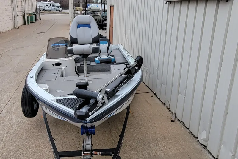 Slide: The Image of 1999 Ranger 107 Cherokee boat on trailer, parked beside a building. - 6