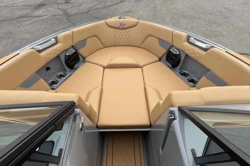 Slide: The Image of 2026 MasterCraft XT23 boat interior with tan seating and cup holders. - 12
