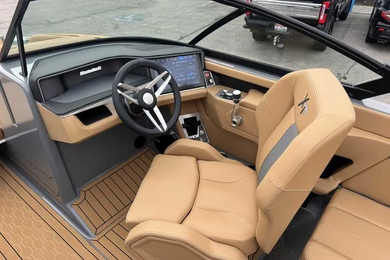 Slide: The Image of 2026 MasterCraft XT23 boat interior with tan seating and modern dashboard controls. - 13