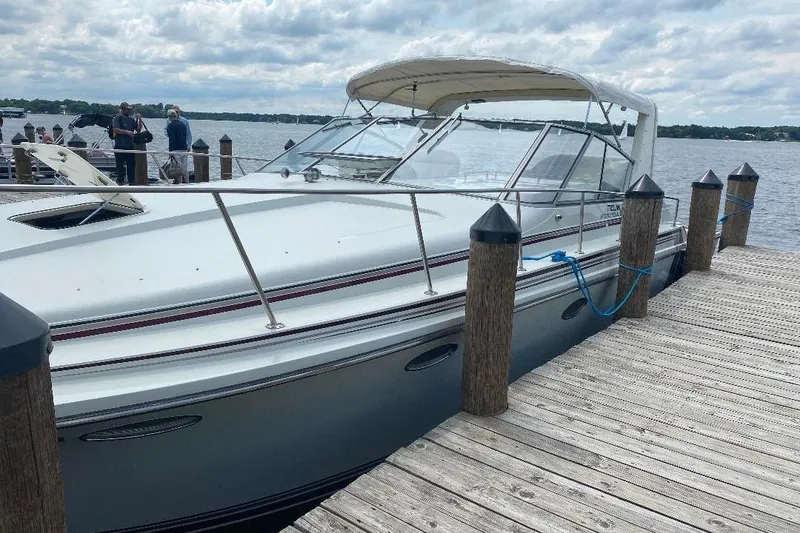 Slide: The Image of 1984 Trojan 11 Meter Express yacht docked at a wooden pier on a cloudy day. - 4