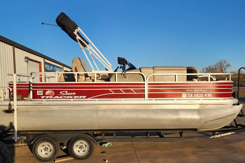 The Image of 2022 Sun Tracker Fishin' Barge 20 DLX pontoon boat on trailer, side view. - 0
