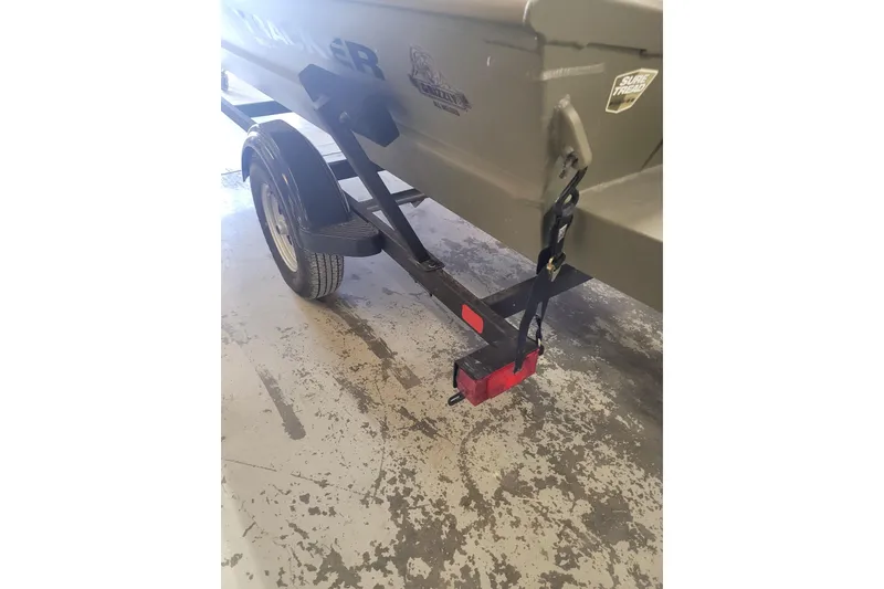 Slide: The Image of 2026 Tracker Grizzly 1860 CC boat trailer with red tail light and black strap. - 13