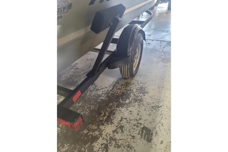 Slide: The Image of 2026 Tracker Grizzly 1860 CC boat trailer on a textured concrete floor. - 14