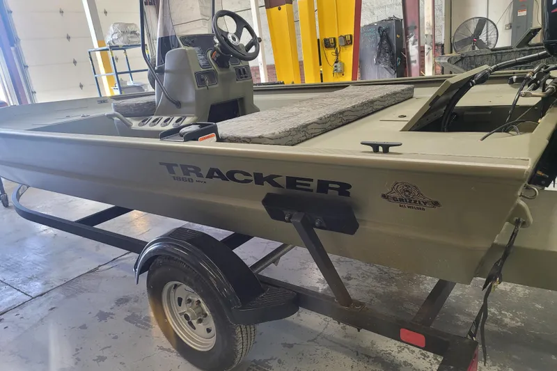 Slide: The Image of 2026 Tracker Grizzly 1860 CC boat on trailer in a garage setting. - 18