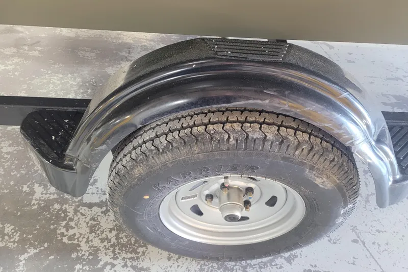 Slide: The Image of Trailer wheel and fender of 2026 Tracker Grizzly 1860 CC on concrete floor. - 21