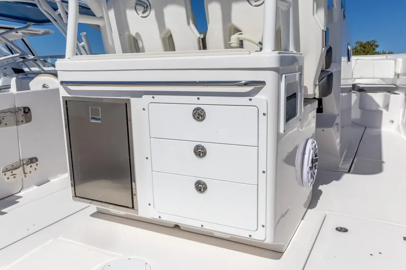 Slide: The Image of 2026 Edgewater 285CC boat interior with storage drawers and stainless steel door. - 15