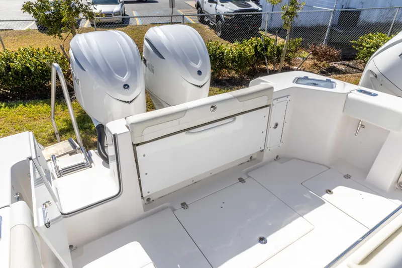 Slide: The Image of 2026 Edgewater 285CC boat with dual outboard engines, parked outdoors. - 16