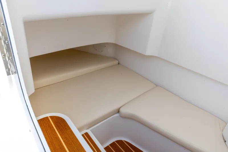 Slide: The Image of 2026 Edgewater 285CC cabin interior with beige cushions and wooden flooring. - 25