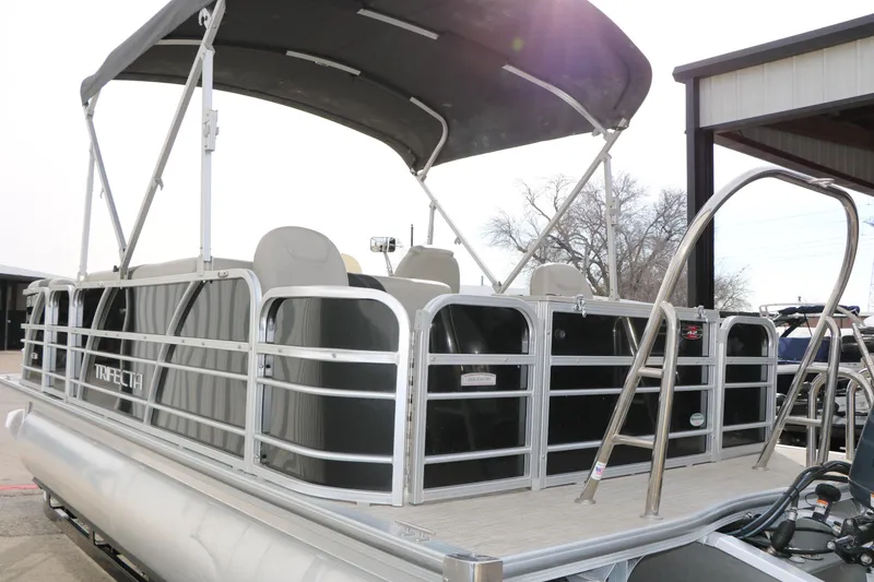 Slide: The Image of 2021 Trifecta 22 RFC pontoon boat with canopy and ladder, docked outdoors. - 14
