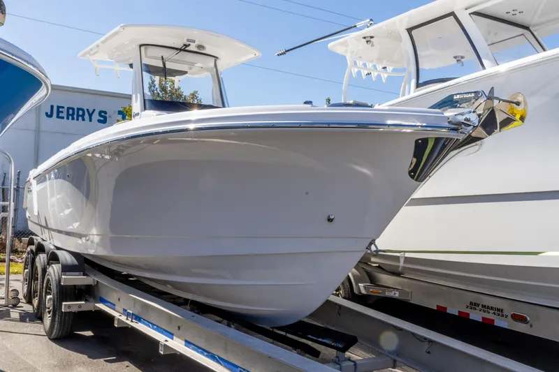 Slide: The Image of 2026 Edgewater 262CC boat on trailer, displayed outdoors in sunlight. - 27