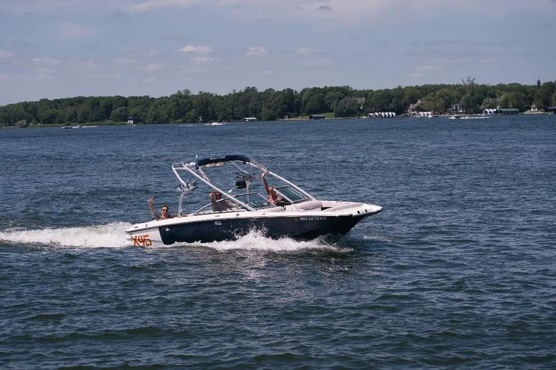 Slide: The Image of 2006 MasterCraft X-45 boat cruising on a lake with passengers waving. - 8