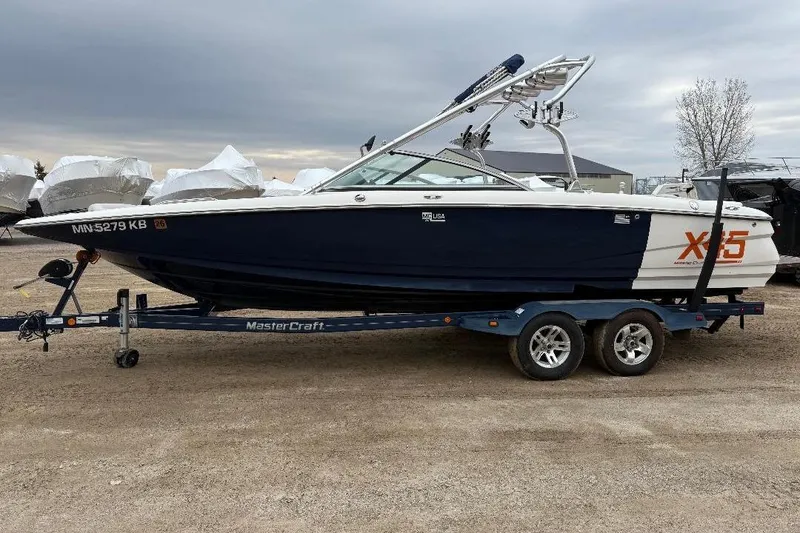 Slide: The Image of 2006 MasterCraft X-45 boat on trailer, parked outdoors under cloudy sky. - 9