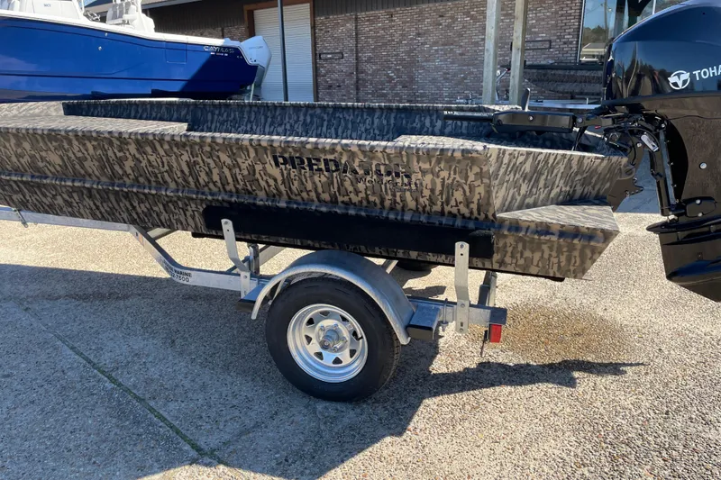 The Image of 2026 Weldcraft 1652 Predator boat with camouflage design on a trailer. - 1