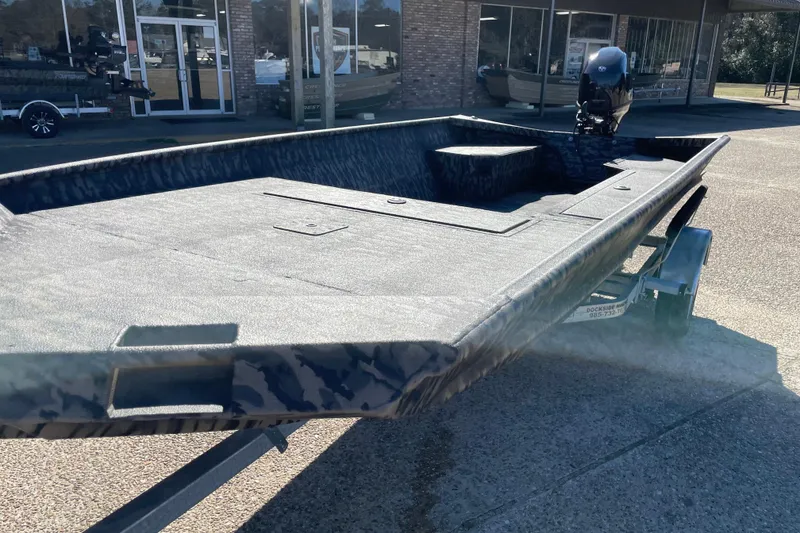 Slide: The Image of 2026 Weldcraft 1652 Predator boat on trailer, camo design, parked outside dealership. - 6