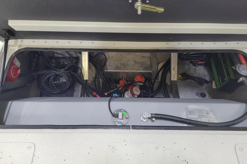 Slide: The Image of 2025 Ranger RB210 boat compartment with wiring and battery setup. - 13