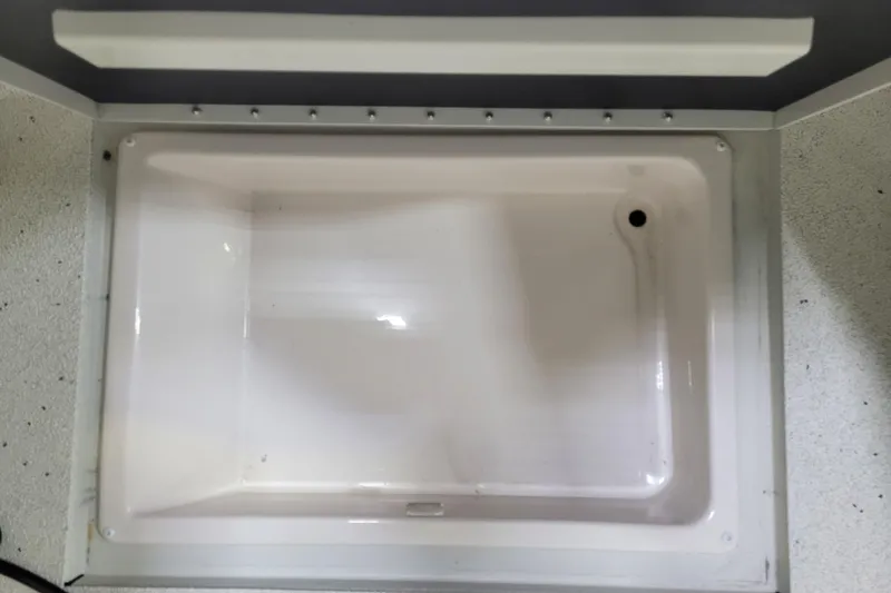 Slide: The Image of Ranger RB210 2025 model livewell, empty and clean, with a drain hole. - 23