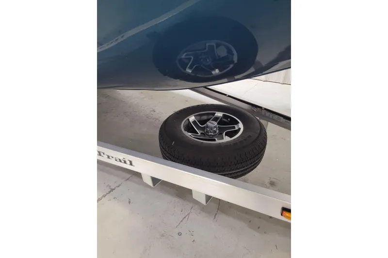 Slide: The Image of 2025 Ranger RB210 trailer with spare tire on display in a garage setting. - 30