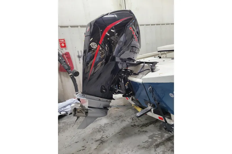 Slide: The Image of 2025 Ranger RB210 boat with powerful outboard motor in a workshop setting. - 31