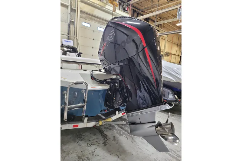 Slide: The Image of 2025 Ranger RB210 boat with powerful outboard motor in a garage setting. - 32