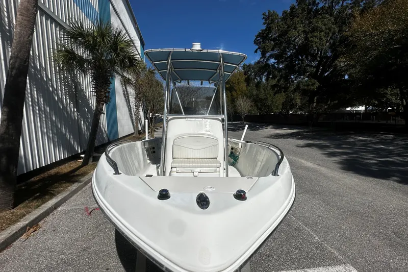 Slide: The Image of 2009 Sea Hawk 210 boat parked outdoors, front view with trees and building. - 3