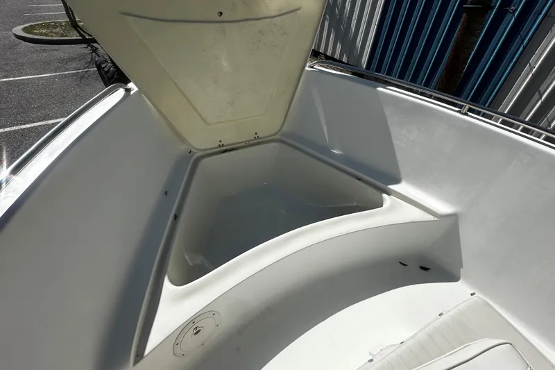 Slide: The Image of 2009 Sea Hawk 210 boat interior with open storage compartment, docked near a blue building. - 5