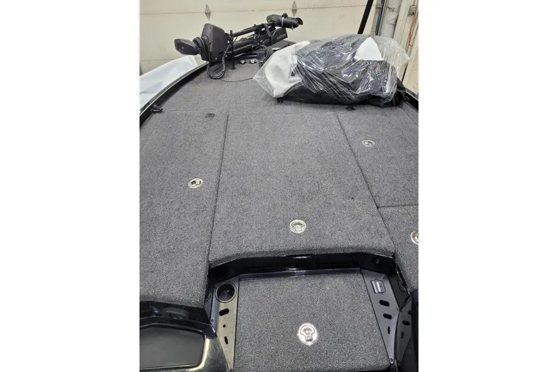 Slide: The Image of 2025 Triton 21XP boat deck with gray carpeting and storage compartments. - 10