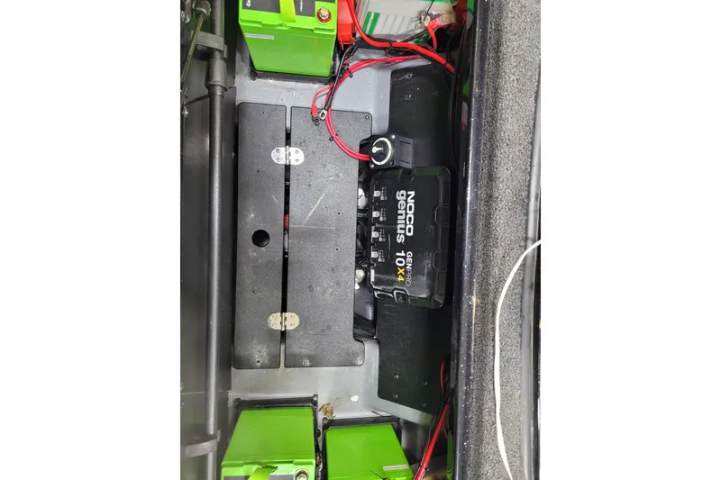 Slide: The Image of Battery compartment of 2025 Triton 21XP with NOCO Genius charger and green batteries. - 16