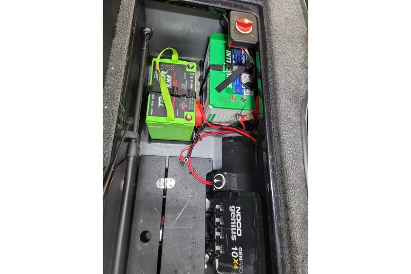 Slide: The Image of 2025 Triton 21XP boat battery compartment with NOCO Genius charger and wiring setup. - 18