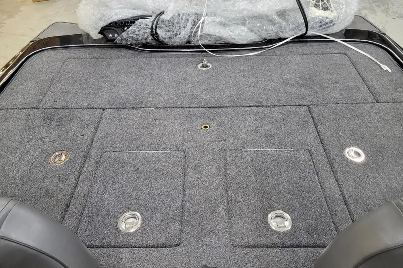 Slide: The Image of 2025 Triton 21XP boat deck with storage compartments and gray carpeting. - 19