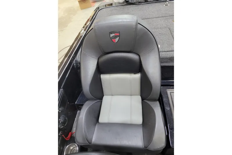 Slide: The Image of 2025 Triton 21XP boat seat, black and gray design, with logo emblem. - 21