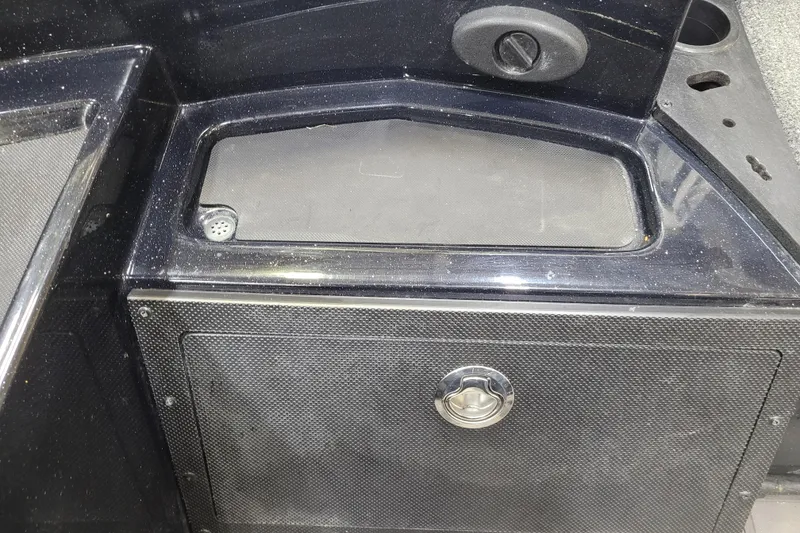 Slide: The Image of 2025 Triton 21XP boat storage compartment with secure latch and drainage feature. - 26